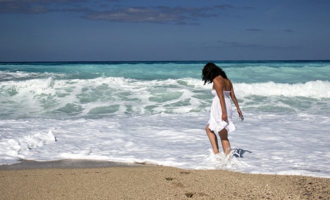 A person in a white dress on a beach Description automatically generated with low confidence