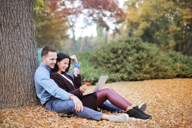 couple reclining beside tree trunks 3764171