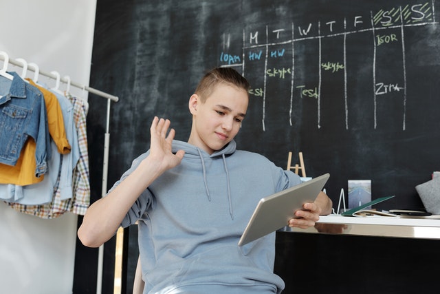 Gambling and Betting Enter Strongly into the Lives of Students 2 photo of boy wearing gray hoodie while using tablet 4144696